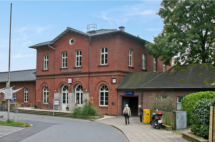 Historisches Backsteingebäude mit der Aufschrift Alter Bahnhof und rundbogigen Fenstern.
