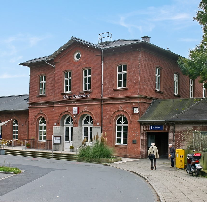 Historisches Backsteingebäude mit der Aufschrift Alter Bahnhof und rundbogigen Fenstern.