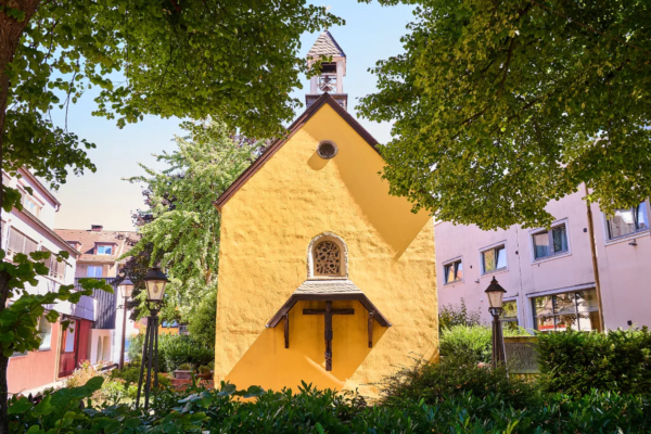 Kleine gelbe Kapelle zwischen Bäumen und Wohnhäusern in Essen-Rüttenscheid