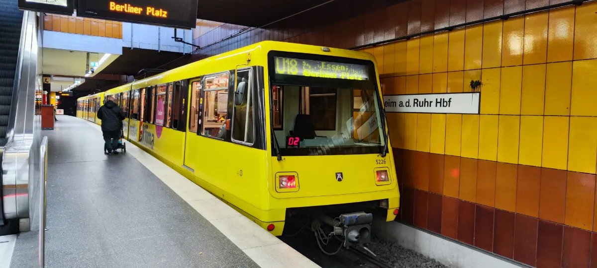 Gelbe Stadtbahn fährt in eine unterirdische Haltestelle ein