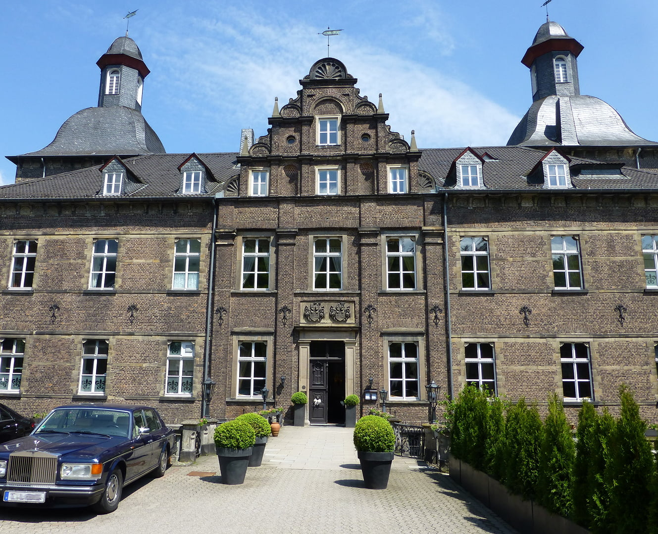 Historisches Herrenhaus mit Backsteinfassade, verziertem Giebel und repräsentativem Eingangsbereich.