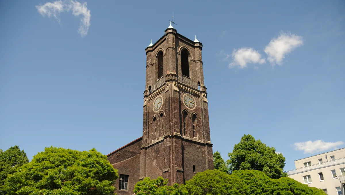 Sandsteinturm einer Kirche vor blauem Himmel im Essener Süden