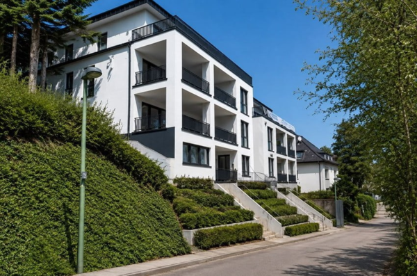 Moderne weiße Wohnanlage mit Balkonen an einem begrünten Hang in einer ruhigen Straße in Essen-Werden.