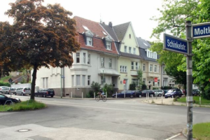 Wohnhäuser an einer Straßenkreuzung in einem ruhigen Stadtviertel.